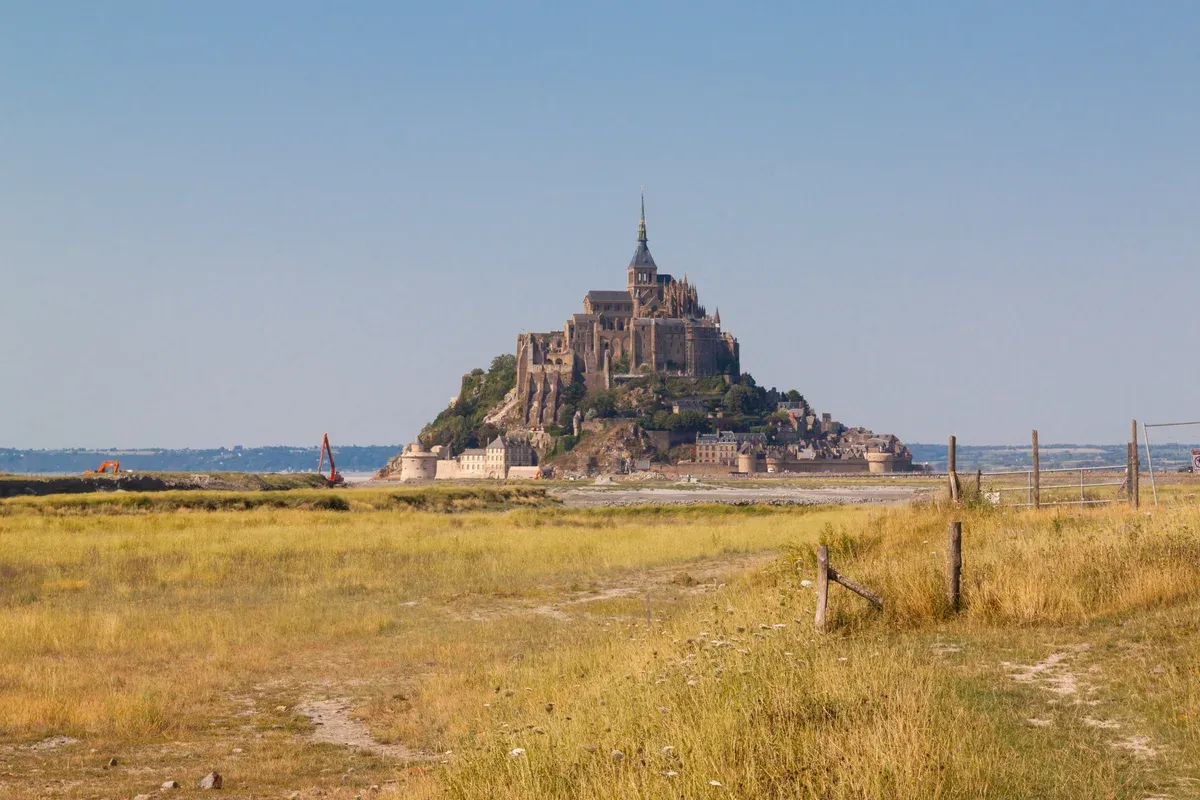 Mont-Saint-Michel and its abbey seen across the salt meadows, the goal of Mont-Saint-Michel tours from Paris, Normandy
